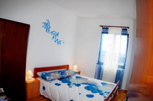 a bedroom with a bed with blue pillows at Apartment Elena, village Peresiji in Peresiji