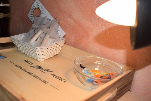 a table with a bowl of candy and a basket of stationery at Hostel il Tetto in Melfi
