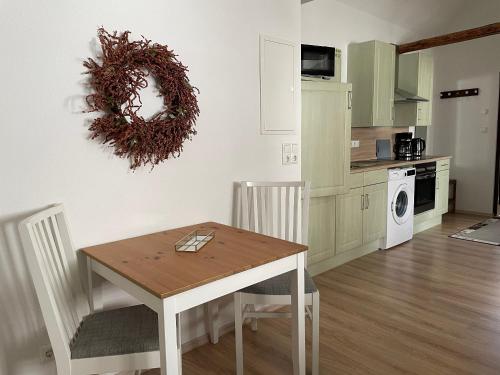 a kitchen with a table and a wreath on the wall at Ferienwohnungen Clara in Arnstadt