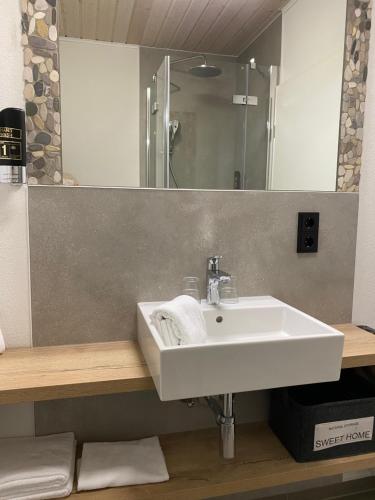a bathroom with a white sink and a mirror at Hotel & Restaurant Kronenhof am Weser-Radweg in Oedelsheim