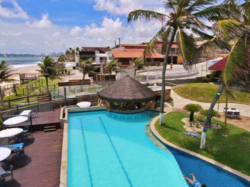 a resort swimming pool with a gazebo and the beach at El Aram Imirá Beach Resort in Natal
