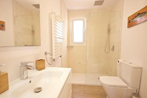 a white bathroom with a sink and a toilet at Villa Maravilla with HEATABLE pool ROOFTOPbar with sea views and Range Rover in Binibeca
