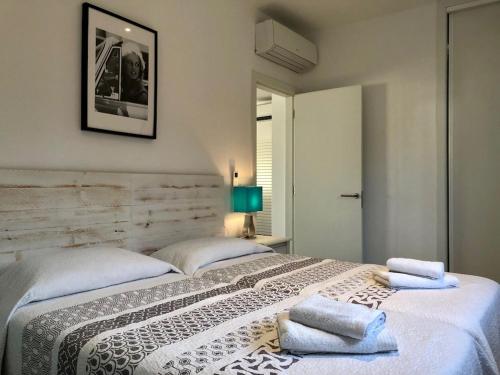 a bedroom with a large bed with towels on it at Villa Maravilla with HEATABLE pool ROOFTOPbar with sea views and Range Rover in Binibeca