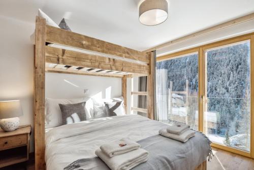 a bedroom with a large bed with towels on it at Chalet Les Rahâs by Mrs Miggins in Grimentz