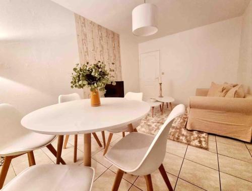 sala de estar con mesa, sillas y sofá en Joli duplex cocooning de 100m2 avec Rez de jardin en Feyzin