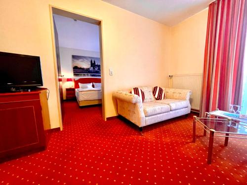 a living room with a couch and a flat screen tv at Mercure Hotel Plaza Magdeburg in Magdeburg