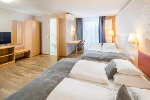 a hotel room with two beds and a television at Hotel Classic in Freiburg im Breisgau