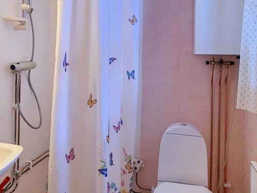 a bathroom with a toilet and a shower curtain with butterflies at Holiday home Tällberg II in Tällberg