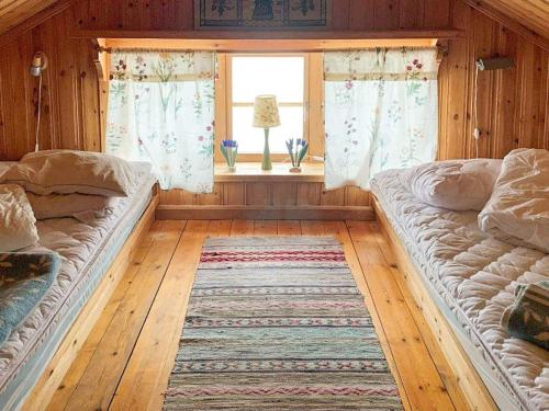 two beds in a room with a window and a rug at Holiday home Tällberg II in Tällberg