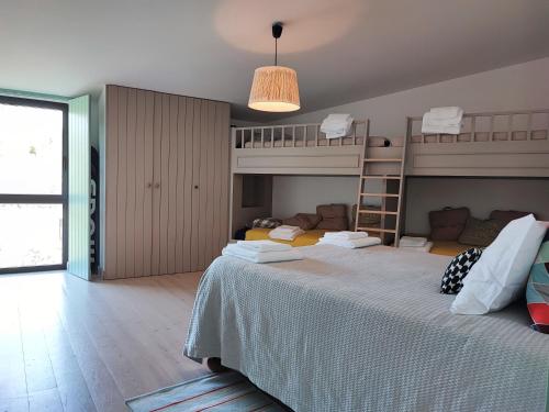 a bedroom with a bed and bunk beds in it at Casa Do Guarda Rios in Ponte Nova