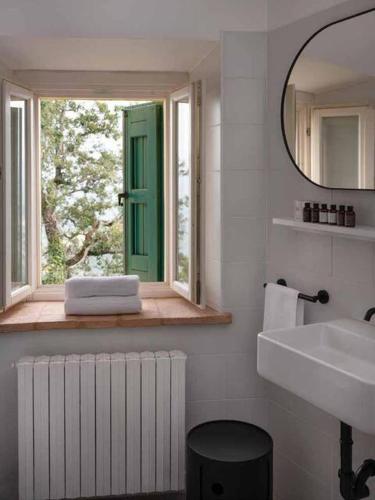 a bathroom with a window and a sink and a mirror at Borgo BiancoMatilde - Boutique Hotel in Casina