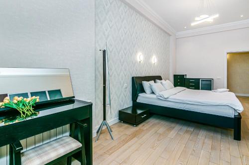 a bedroom with a bed and a desk with a piano at Luxury House in Nizami Street in Baku