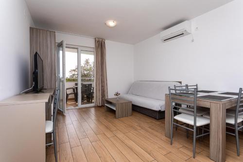 a bedroom with a bed and a table with a desk at Apartments Crnekovic Tomislava 8 in Baška