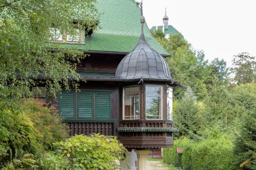 a house with a green roof and a balcony at Villa Schönthaler in Semmering