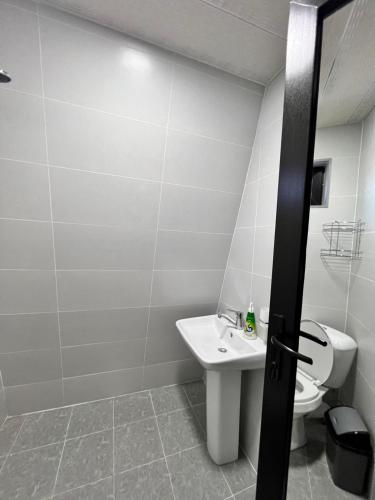 a bathroom with a white toilet and a sink at Cottage Orcs in Borjomi