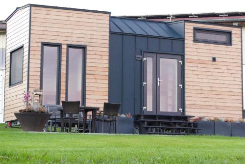 a tiny house with a table and chairs in a yard at TinyHouse -Reset im Vilstal -Zurück zum Ursprung in Aldersbach