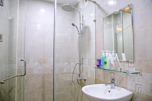 y baño con ducha, lavabo y cabina de ducha acristalada. en Green Sand Homestay en Hoi An