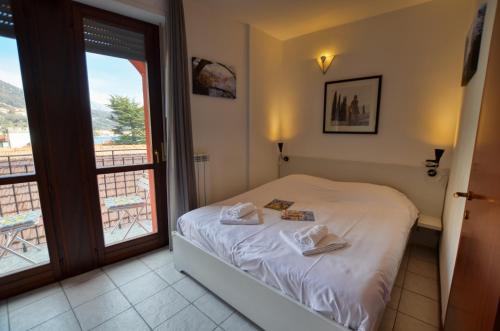 a bedroom with a bed and a door to a balcony at Lake View Apartment Golden Triangle in Acquaseria