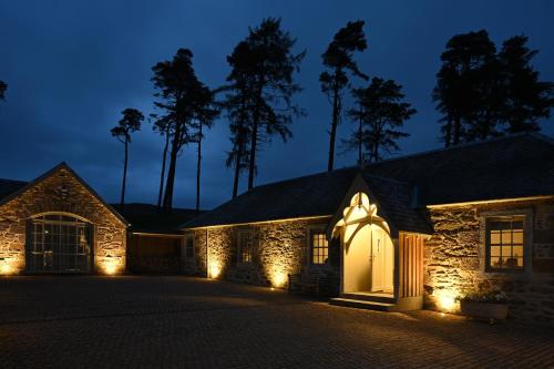 uma casa de pedra com luzes na entrada à noite em Stables Cottage em Perth