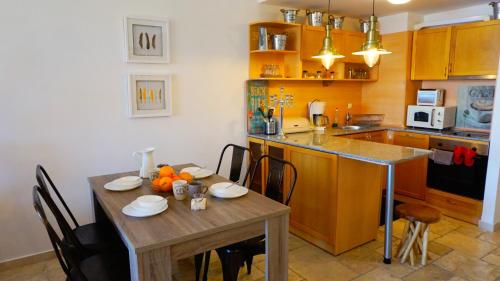 uma cozinha com uma mesa de madeira e uma sala de jantar em Apartment DECORA Sea View em Topola