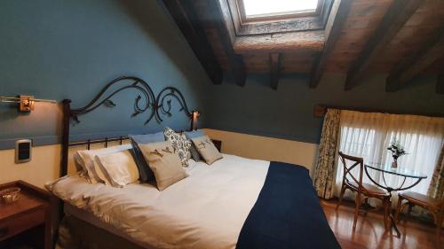 a bedroom with a bed and a table with a window at El Rincón de Rascafría in Rascafría