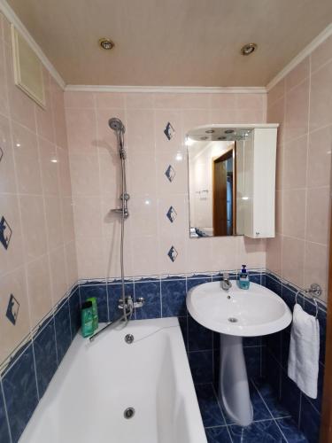 a bathroom with a tub and a sink and a bath tub at 1 комнатная квартира в самом центре с видом на сквер in Kostanay