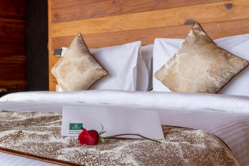 a white bed with a red rose on it at Le ROI Floating Huts & Eco Rooms Tehri in Tehri-Garhwāl