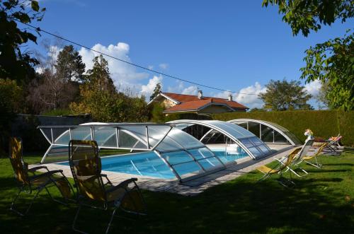 a swimming pool with a tent and chairs in a yard at Chez Patou - Chambres d'hôtes in Beauzac