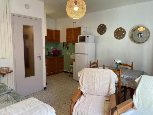 eine Küche mit einem Tisch und einem weißen Kühlschrank in der Unterkunft Studio amelie proche des thermes 2ieme étage in Amélie-les-Bains-Palalda