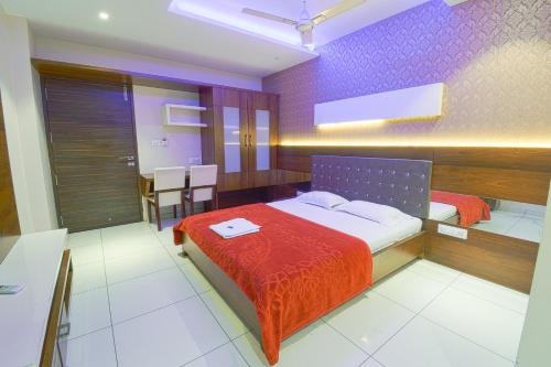 a bedroom with a bed with a red blanket at Hotel Ravikiran Kolhapur, NEAR GOKUL SHIRGAOV MIDC, KANERIWADI, 5 STAR MIDC, ON NH4 GOA HIGHWAY in Kolhapur