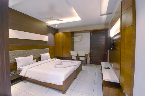 een slaapkamer met een bed en een tafel. bij Hotel Ravikiran in Kolhapur