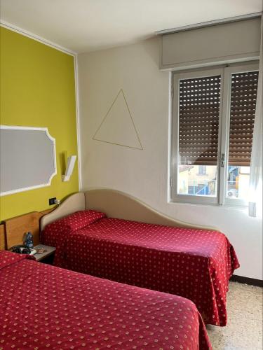 a hotel room with two beds and a window at Hotel San Marco BB in Boario Terme