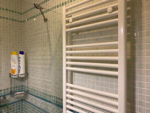 a shower with green tiled walls and a window with shutter at Ático Cádiz Playa in Cádiz