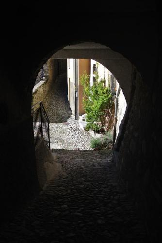 an alley way with an archway in a building at A Cà balade in Design in Miglieglia