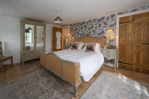 a bedroom with a large bed with white sheets and pillows at Laverockbank Farmhouse in Perth