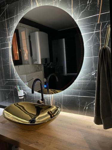 a bathroom with a sink and a round mirror at Ranch Falcone in Hrvatska Dubica