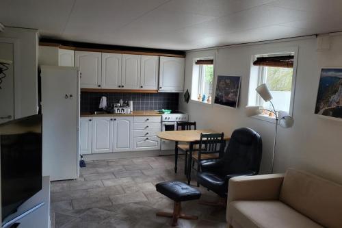 een keuken met een tafel en stoelen in een kamer bij Flott leilighet i stille og rolig område, med gratis privat parkering! in Stavanger