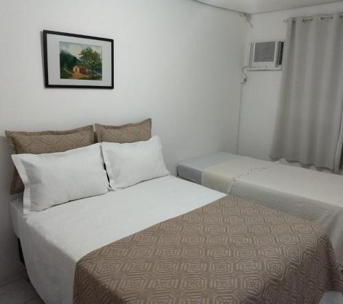Habitación de hotel con 2 camas y ventana en casa da Lú, en Florianópolis