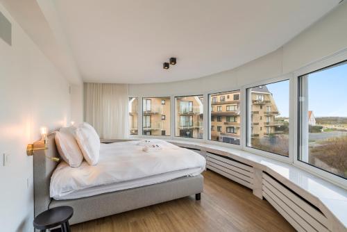 1 dormitorio con 1 cama y ventanas grandes en Villa Paradis - De ultieme kustvilla met zwembad !, en Koksijde