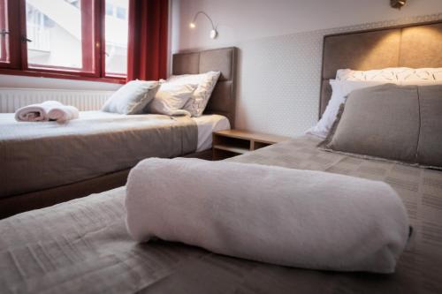 a hotel room with two beds and a window at Apartments Pia in Subotica