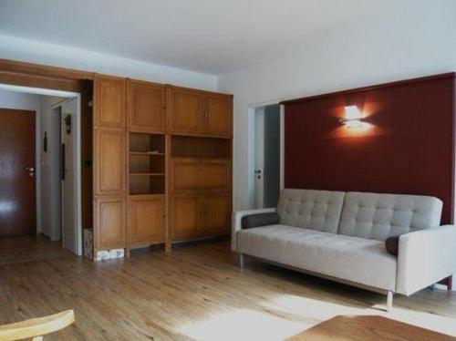 a living room with a couch and wooden cabinets at Falkenberg-Wohnung-112 in Oberstdorf