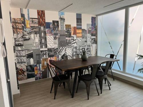 a table and chairs in a room with a wall mural at Depto nuevo cerca del Teatro Caupolicán y Movistar Arena in Santiago