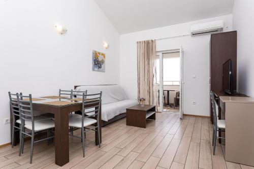 a living room with a dining room table and a bed at Apartments Crnekovic Tomislava 8 in Baška