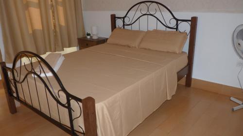 a bedroom with a bed with a metal frame at KAZARÃO DI MAVETE- Guesthouse in Praia