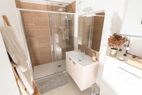 La salle de bains blanche est pourvue d'une douche et d'un lavabo. dans l'établissement Le Héron Nantais, à Nantes