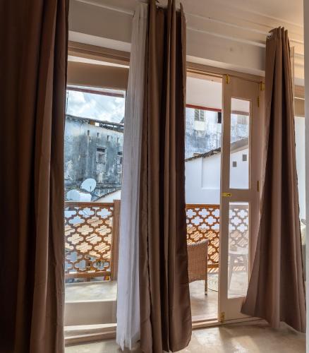 a room with a view of a balcony with curtains at Sharazad Wonders Boutique in Zanzibar City