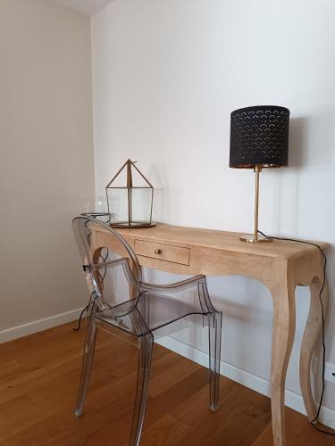 a wooden desk with a chair and a lamp at Les Galets Hôtel et B&B in Bandol
