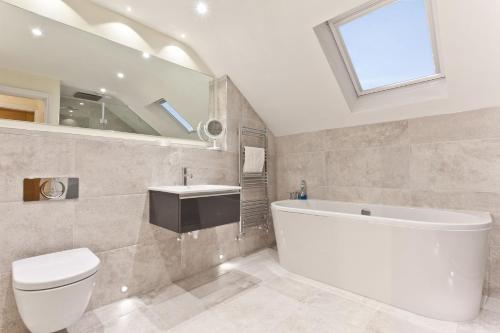 a bathroom with a tub and a toilet and a sink at Forge Bridge Cottage Coniston in Coniston
