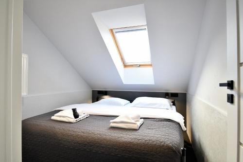1 dormitorio con 1 cama con 2 toallas en Sleepinn Gdansk Airport en Gdańsk-Rębiechowo