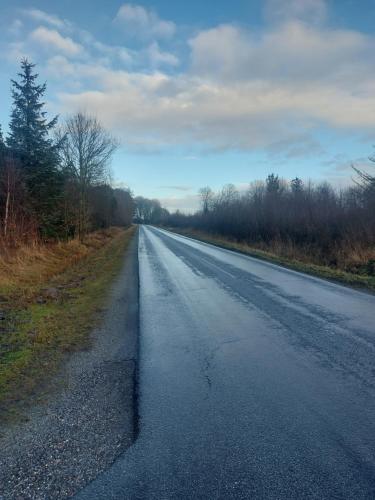 an empty road in the middle of a field at KRAGKAER Deer-Lodge B&B & Guest House - Unique Holiday Homes in Sæby